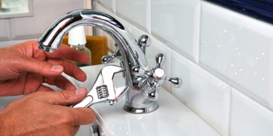 someone fixing a faucet