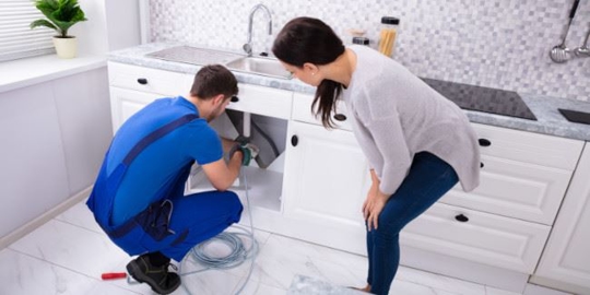 a plumber fixing under a sink
